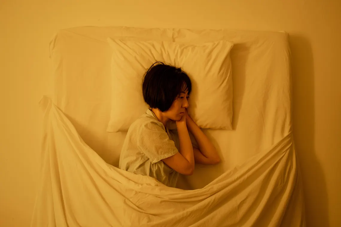 A person lying awake in bed at night
