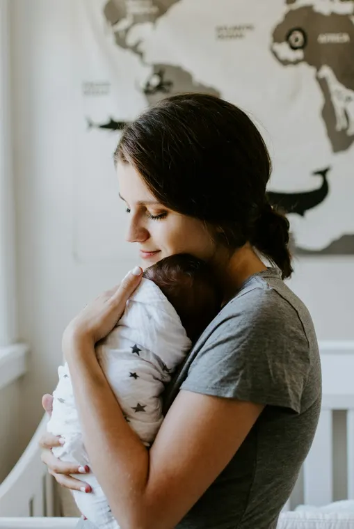 A mother holding her newborn baby close